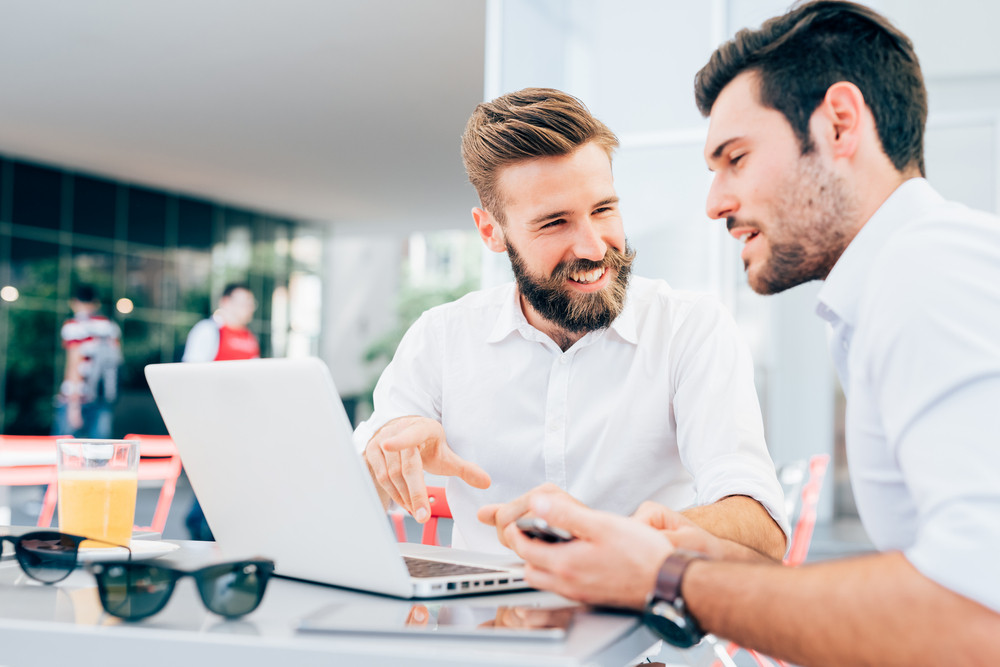 two-people-looking-computer-smiling-choosing-the-right-coaching-platform-software-potentia-header-blog